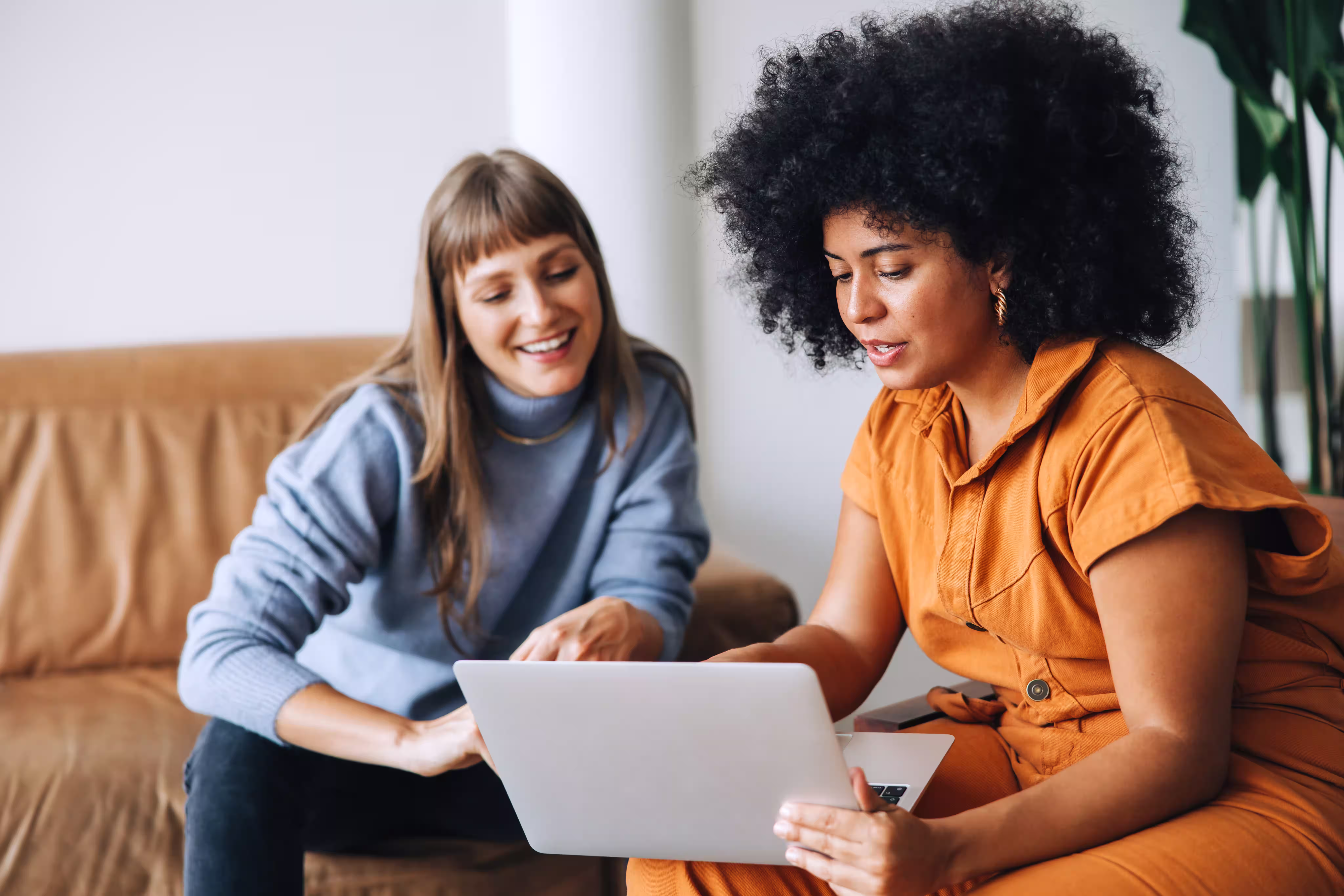 Businesswomen having a discussion while using a laptop in an office